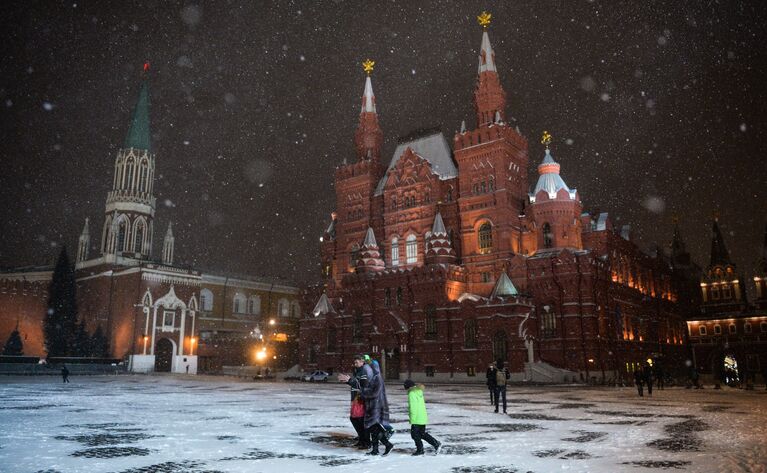 Прохожие во время снегопада на Красной площади в Москве