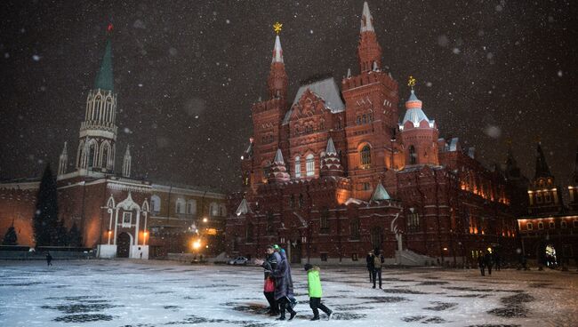 Прохожие во время снегопада на Красной площади в Москве