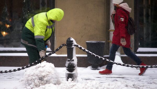 Мужчина убирает снег на Невском проспекте в Санкт-Петербурге