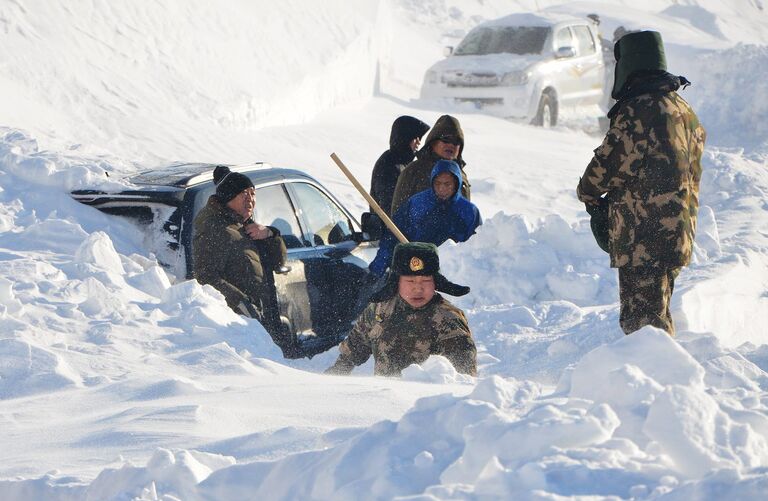 Полицейские откапывают автомобиль от снега на Алтае, Китай