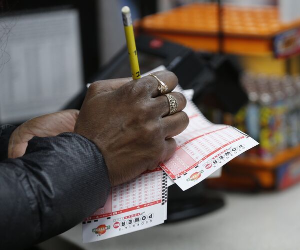 Мужчина проверяет лотерейные билеты Powerball максимальный выигрыш которой на данный момент составляет 1,5 миллиарда долларов