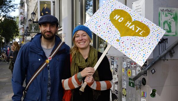 Жители с плакатом No hate на улице Гамбурга