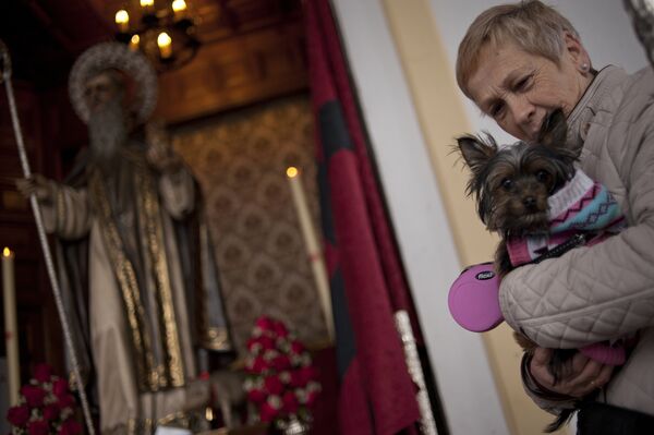 Женщина со своей собакой в церкви на День святого Антония