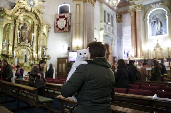 Женщина со своими питомцем в церкви на День святого Антония