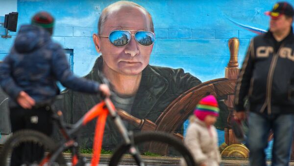 Прохожие у портрета президента России Владимира Путина на стене здания в Ялте. Архивное фото
