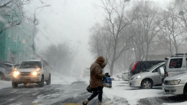 Прохожий на Комсомольской улице во время снежного циклона во Владивостоке