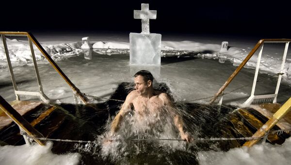 Мужчина во время купания в озере Валдайского Иверского Святоозерского монастыря