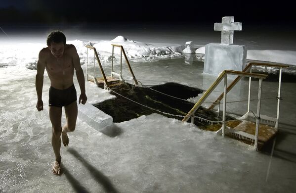 Мужчина во время купания в озере Валдайского Иверского Святоозерского монастыря