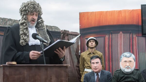 Актеры в масках Игоря Коломойского и Михаила Саакашвили (справа налево) во время перформанса Процесс