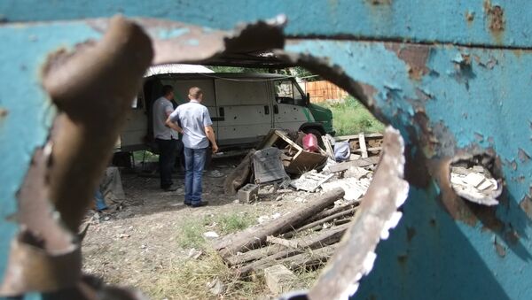 Дыра в воротах одного из домов от попадания осколка от снаряда в результате обстрела украинских силовиков. Донецк