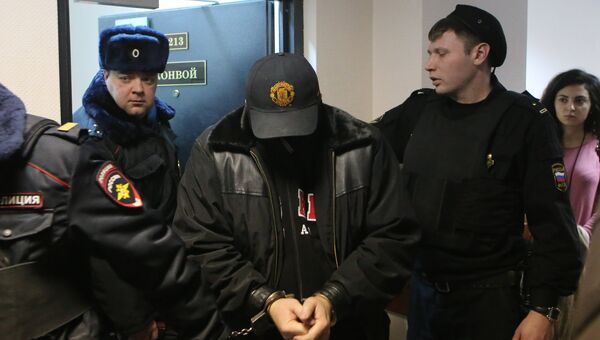 Сотрудники полиции ведут Александра Величко, подозреваемого в убийстве директора компании Мон-компани