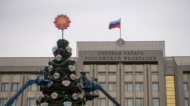 Рабочие украшают новогоднюю елку, установленную у Счётной Палаты РФ, в Москве. Архивное фото