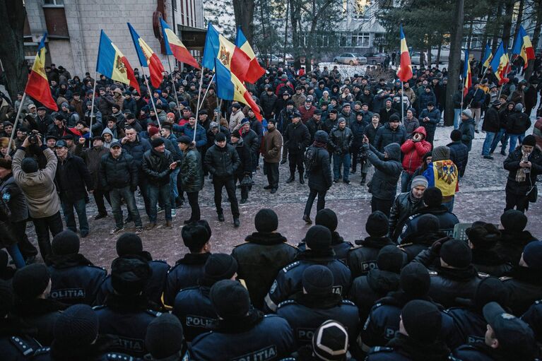 Протестующие и сотрудники правоохранительных органов у здания парламента в Кишиневе