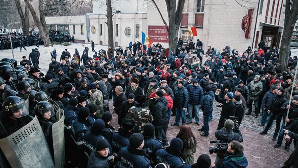 Протестующие и сотрудники правоохранительных органов у здания парламента в Кишиневе