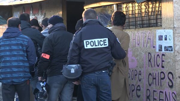 Полицейские увели в наручниках задержанных мигрантов из лагеря в Кале