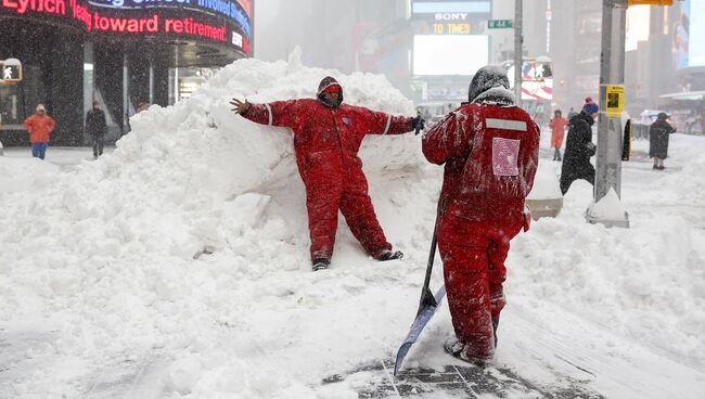 Сотрудники коммунальной службы Нью-Йорка фотографируются на фоне сугробов после снегопада. Январь 2016