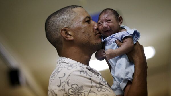 Отец держит своего больного микроцефалией сына в больнице города Ресифе, Бразилия