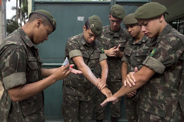 Военнослужащие обрабатывают руки репеллентом перед операцией по борьбе с комарами, переносящими вирус Зика, в Сан-Паулу, Бразилия