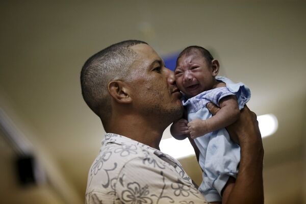 Мужчина держит на руках своего ребенка в больнице города Ресифи, Бразилия