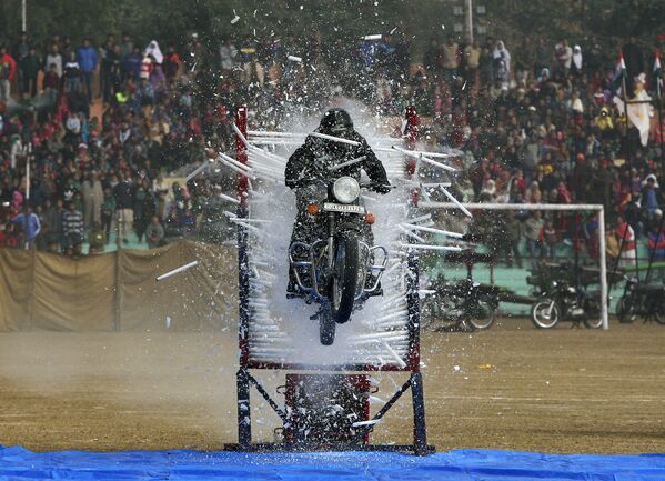 Полицейский выполняет трюк на мотоцикле во время парада по случаю Дня республики в Индии