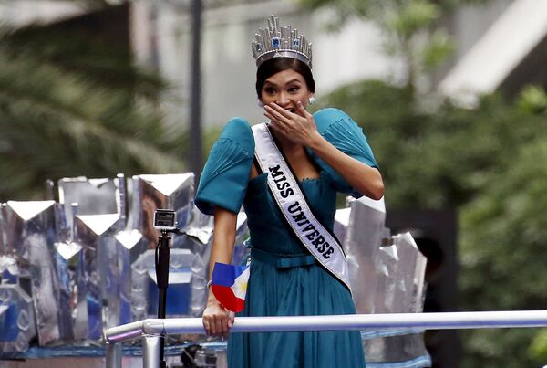 Мисс Вселенная Пиа Алонсо реагирует на фаната в самодельной короне во время движения кортежа в Маниле. Январь 2015