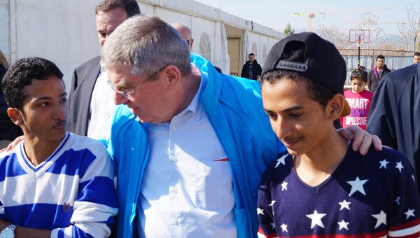 Президент Международного олимпийского комитета Томас Бах и иранский футболист Фархад Такалу в центр размещения беженцев в афинском районе Элеона