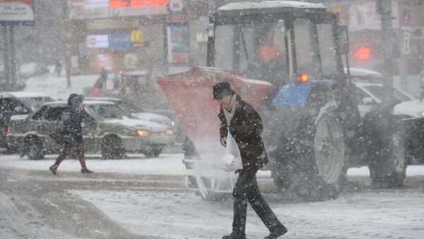 Мужчина переходит дорогу в Москве во время снегопада. Архивное фото