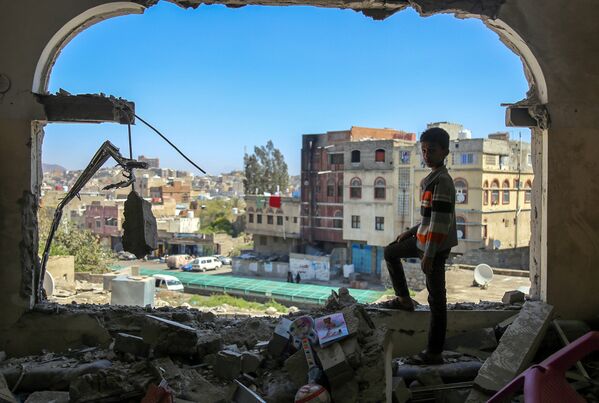 Мальчик осматривает разрушенное здание после атаки на город Таиз в Йемене. Февраль 2016