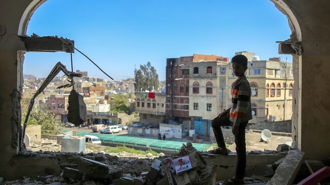 Мальчик осматривает разрушенное здание после атаки на город Таиз в Йемене.Архивное фото