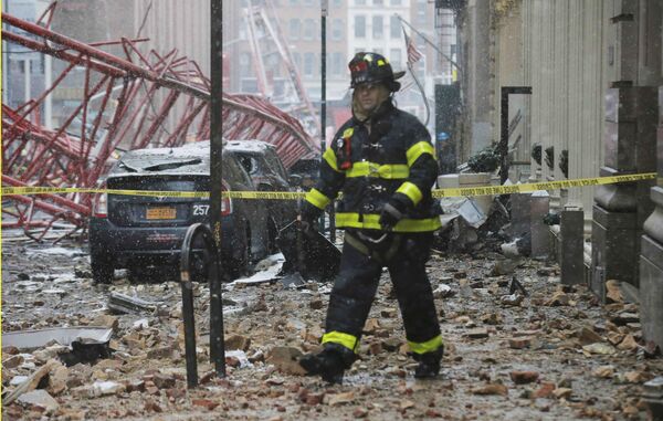 Пожарный на месте обрушения подъемного крана в Нью-Йорке, США. 5 февраля 2016