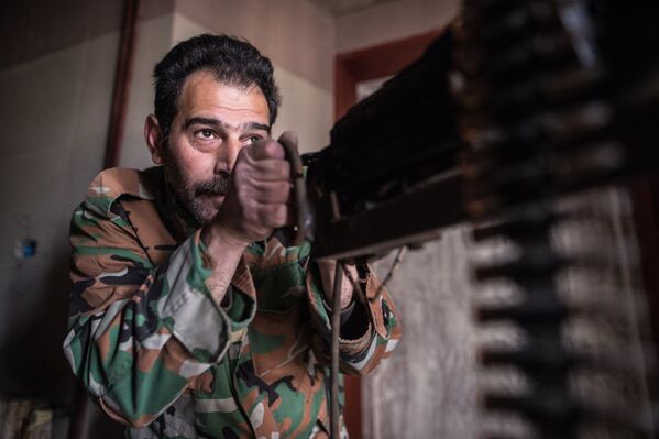 Солдат сирийской армии наблюдает за районом города Хомса Ваер