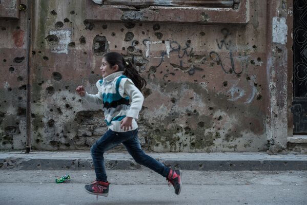 Девочка играет в районе Старого города в Хомсе