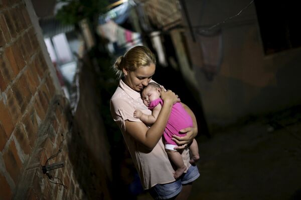 Мать держит свою больную микроцефалией дочь в Ресифи, Бразилия