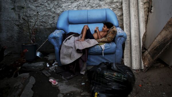Ребенок лежит на диване возле своего дома в Бразилии