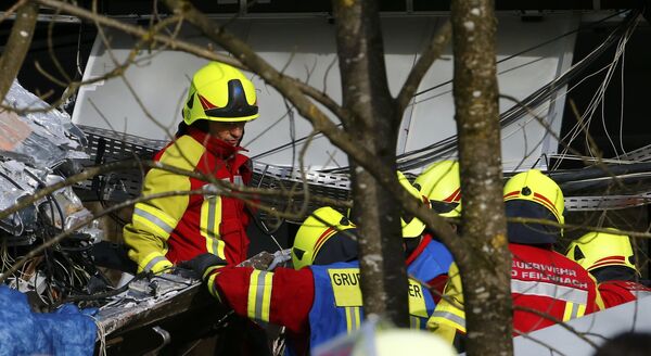 Сотрудники службы спасения работают на месте столкновения двух пассажирских поездов в Германии. 9 февраля 2016