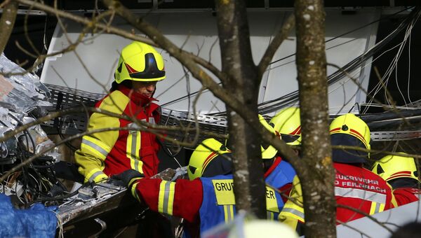 Сотрудники службы спасения работают на месте столкновения двух пассажирских поездов в Германии. 9 февраля 2016