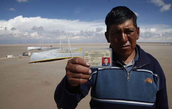 Рыбак показывает свою лицензию у высохшего озера Поопо, Боливия. Январь 2016