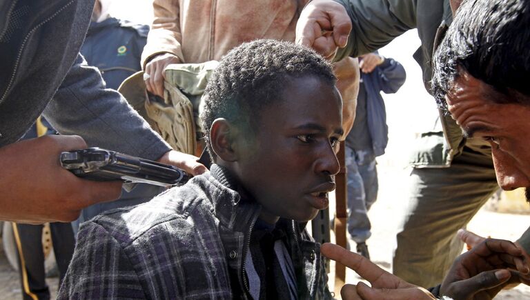 Захваченный повстанцами в плен сторонник Каддафи. Март 2011