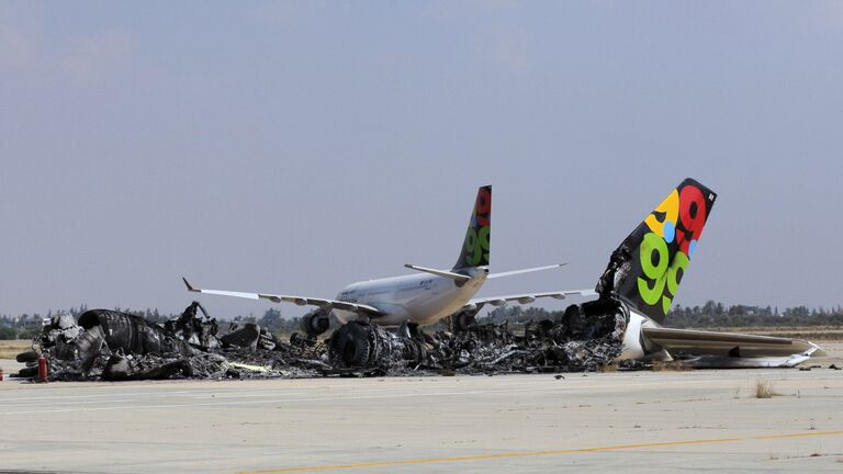 Сгоревший в результате обстрела пассажирский лайнер в аэропорту Триполи, Ливия. Август 2011
