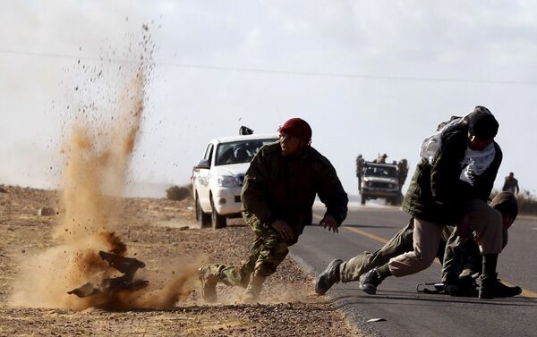 Бойцы оппозиции под обстрелом войск Каддафи у города  Бин-Джавад, Ливия. Март 2011