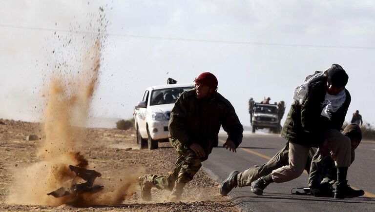 Бойцы оппозиции под обстрелом войск Каддафи у города  Бин-Джавад, Ливия. Март 2011