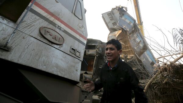 Мальчик возле сошедшего с рельсов поезда в Египете. 11 февраля 2016 год