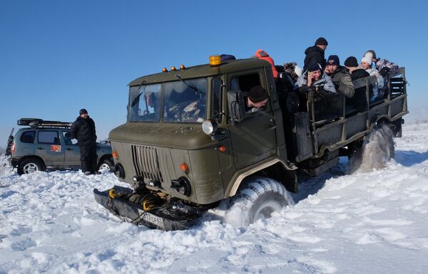 Зрители в кузове грузовика ГАЗ-66 во время ежегодного автомобильного спортивно-туристического внедорожного мероприятия Снежный беспредел