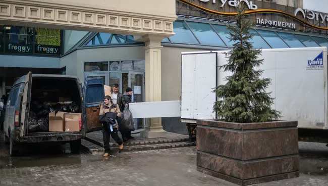 Рабочие выносят имущество из торгового центре Пирамида на Пушкинской площади Москвы. Архивное фото