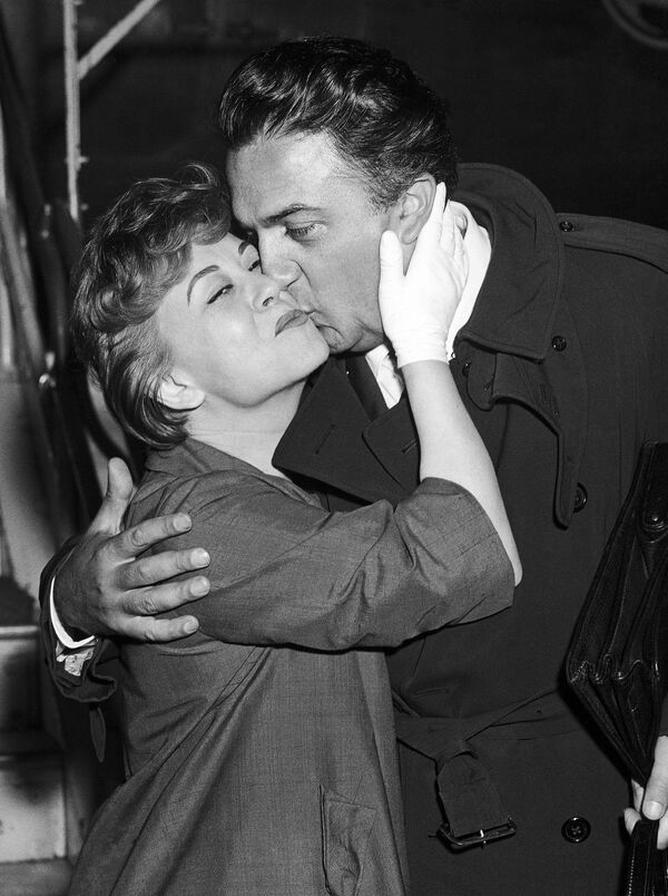 Итальянский кинорежиссер Федерико Феллини с женой актрисой Джульеттой Мазиной во время прибытия на Международный кинофестиваль в Берлине, 27 июня 1958