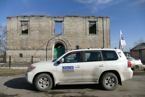 Автомобиль ОБСЕ у разрушенного дома в поселке Зайцево в Донецкой области