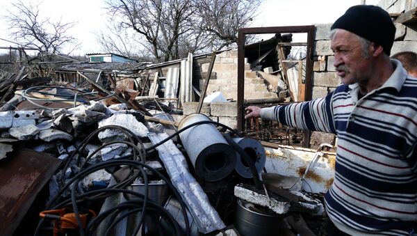Местный житель у разрушенного дома в поселке Зайцево в Донецкой области. Архивное фото