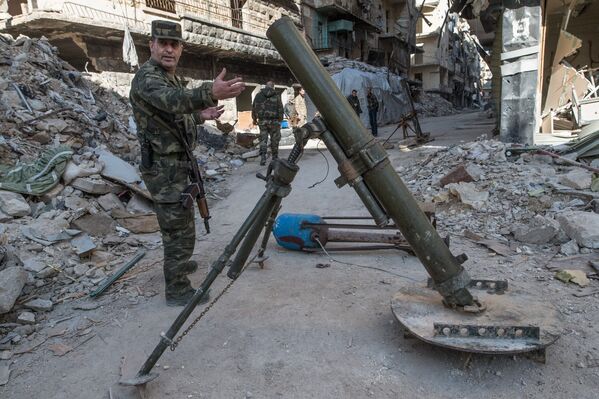 Военнослужащий Сирийской Арабской армии показывает захваченную установку