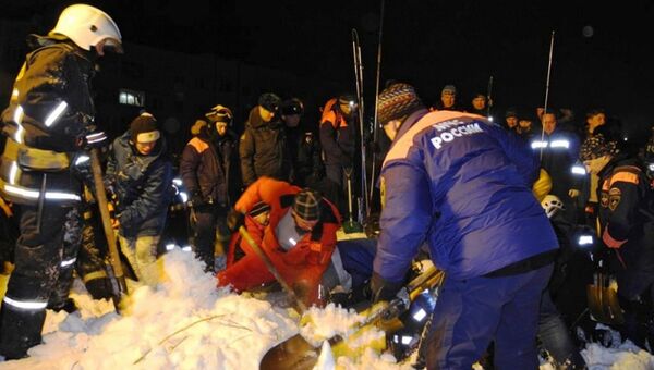Спасатели МЧС расчищают от снега места схода лавины в городе Кировске Мурманской области