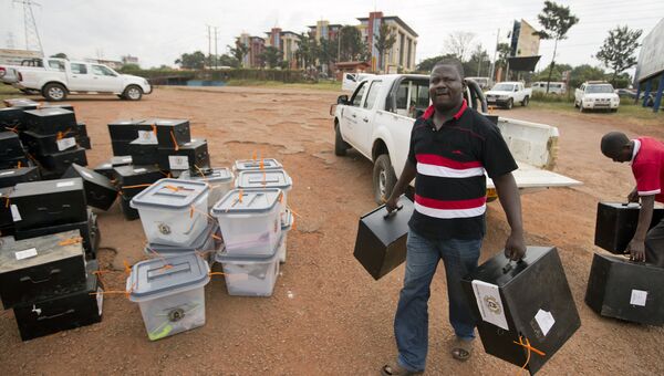 Работник избирательной комиссии несет коробки с бюллетенями в центр подсчета в Кампале, Уганда. 20 февраля 2016
